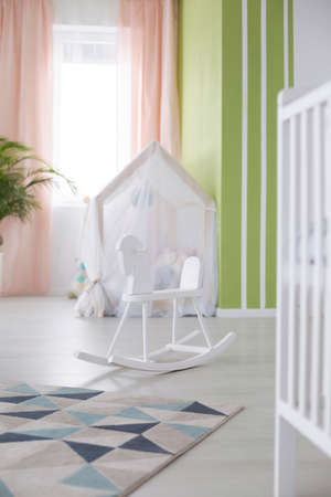 White rocking horse in cozy spacious living roomの写真素材