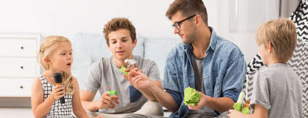 Young handsome man taking care of his younger siblingsの写真素材