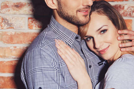 Handsome young man hugging his pretty smiling girlfriendの写真素材