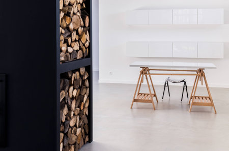 Simple interior in scandinavian style with white built-in kitchen cabinets and shelfs for wood storageの写真素材