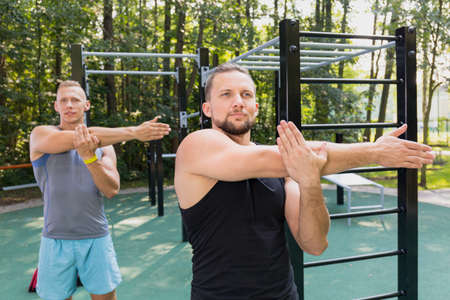 Two young men exercising at outdoor gymの写真素材
