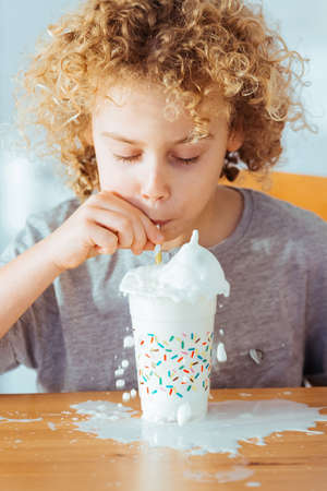 Small boy drinking milk using drinking strawの写真素材
