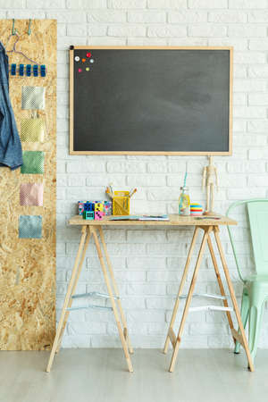 Creative modern room with desk and blackboard on brick wallの写真素材
