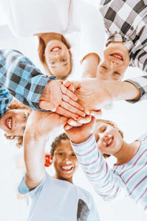 Group of happy children having their hands piled on top of each otherの写真素材