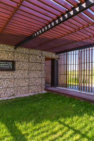 Exterior view of a villa gate with wooden pergola over patioの写真素材