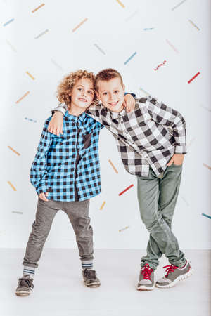 Two happy young boys standing and embracing each otherの写真素材
