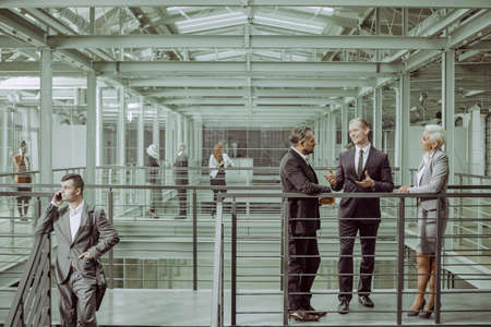 Business partners negotiating conract, talking in office buildingの写真素材