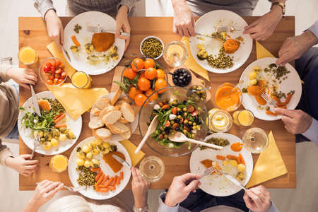Top view of family eating healthy meal beside tableの写真素材