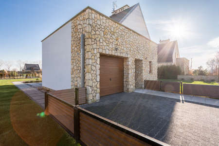 Villa with wood fence, garage and stonework elevationの写真素材