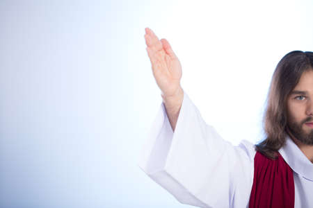 Silhouette of Jesus raising his hand, isolated on bright background