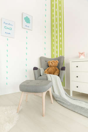 Scandi style, white baby room with grey armchair, dresserの写真素材