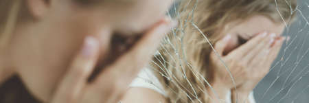 Alone and broken girl covering face by handsの写真素材