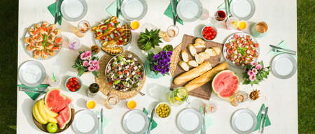 Picnic table full of food on a sunny dayの写真素材