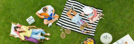 Relaxed and satisfied friends at picnic in parkの写真素材