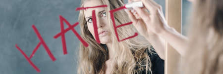 Girl writing on the mirror using red lipstickの写真素材