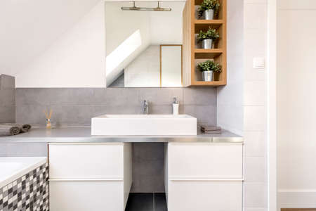 Grey bathroom with white cabinets and mirrorの写真素材