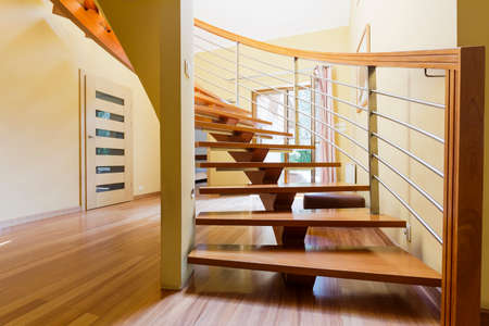 Stairway with wooden steps in a spacious hall of a modern house
