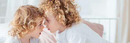 Two young brothers cuddling together in the morningの写真素材