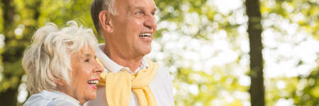 Senior couple standing in a park and laughing