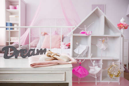 Room interior with cozy bed and stylish dollhouseの写真素材