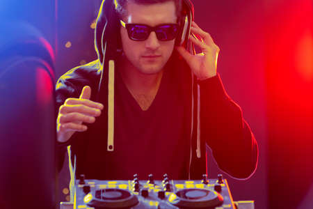 Dj pplaying electronic music, mixing on modern turntable