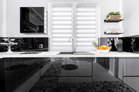 Up-to-date decor of stylish kitchen with shining black and white unitsの写真素材
