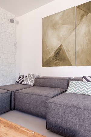 Grey fabric corner sofa in trendy simple living roomの写真素材