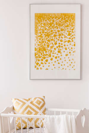 Toddler bedroom with white cradle, wall poster and pattern pillowの写真素材
