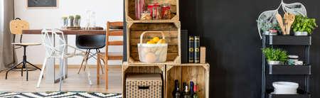 Stylish spacious dining area with wooden boxes and big tableの写真素材