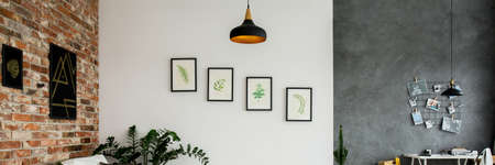 Brick wall, white wall and grey wall decorated with pictures in modern living roomの写真素材