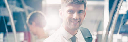 Young smiling handsome businessman travelling by trainの写真素材