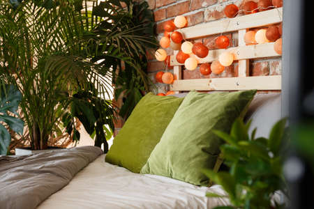 Exotic modern bedroom design with green pillows and cotton ballsの写真素材