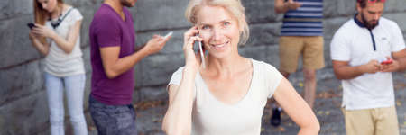 Different people using their smartphones outdoorsの写真素材