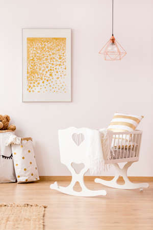 White, nursery room with cradle, copper lamp and wall posterの写真素材