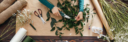 Young talented florist preparing bouquet for orderの写真素材