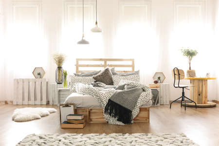 Decorated stylish bedroom interior with wooden furniture