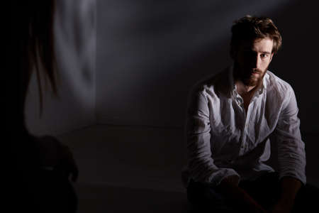 Dark room with man looking at his interlocutorの写真素材