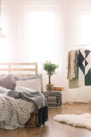 King-size bed and woman's clothes in modern bedroom