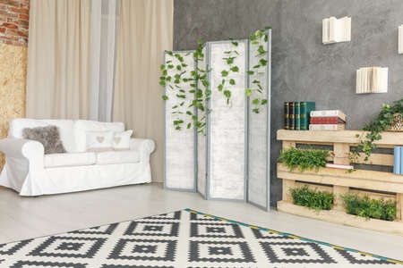 White lounge designed in garden style with white sofa and small bookshelfの写真素材