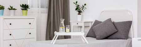 Shot of a cozy white bedroom with a single bedの写真素材