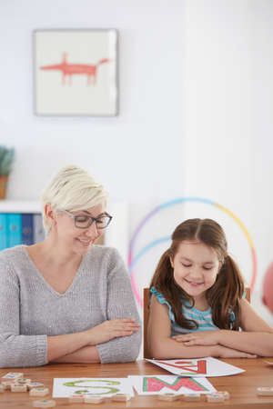 Young girl enjoying speech therapy with smiling therapist