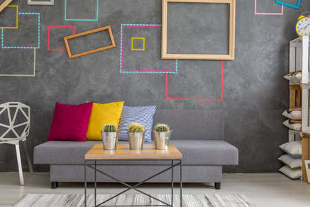 Trendy living room with decorative wall squares and grey sofaの写真素材