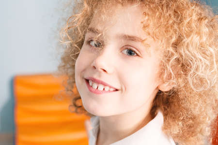 Portrait of happy young boy with blonde, curly hair