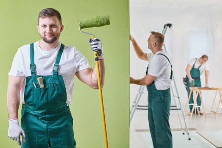 Renovation crew is  keeping a roller and painting the wallの写真素材