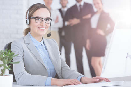 Friendly smiling call center operator at her workplaceの写真素材