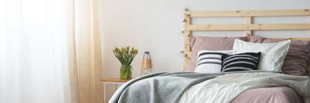 Contemporary design of simple pink and grey bedroom with wooden bedの写真素材