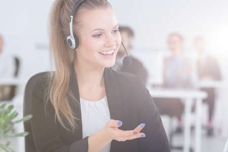Happy female support phone operator at workの写真素材