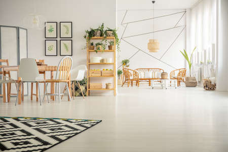 White, open plan home interior with table, chair, pattern carpetの写真素材