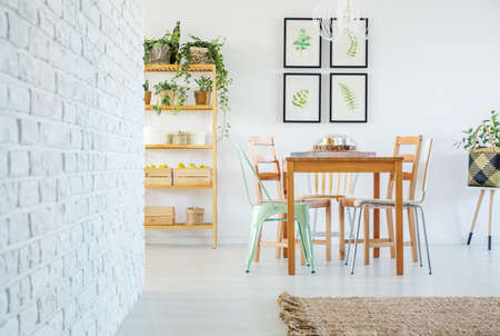 Apartment with white brick wall, table, chair and bookshelf