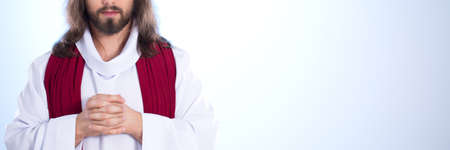 Jesus Christ standing against white background and prayingの写真素材